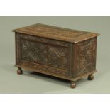 An Edwardian carved oak coffer, of small proportions, with carved front,