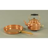 A heavy copper shallow pan, with wood handle and brass mount,