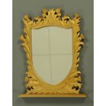 A carved and giltwood shield shape mirror,