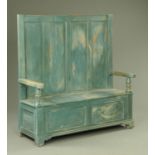 A painted pine high back settle, having a plain four panel back with shaped arm rests,