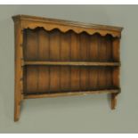 An oak Delft rack, with moulded cornice, shaped apron, open shelves and with shaped supports.