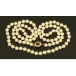 A string of pearls, with 9 ct gold seed pearl and garnet clasp,