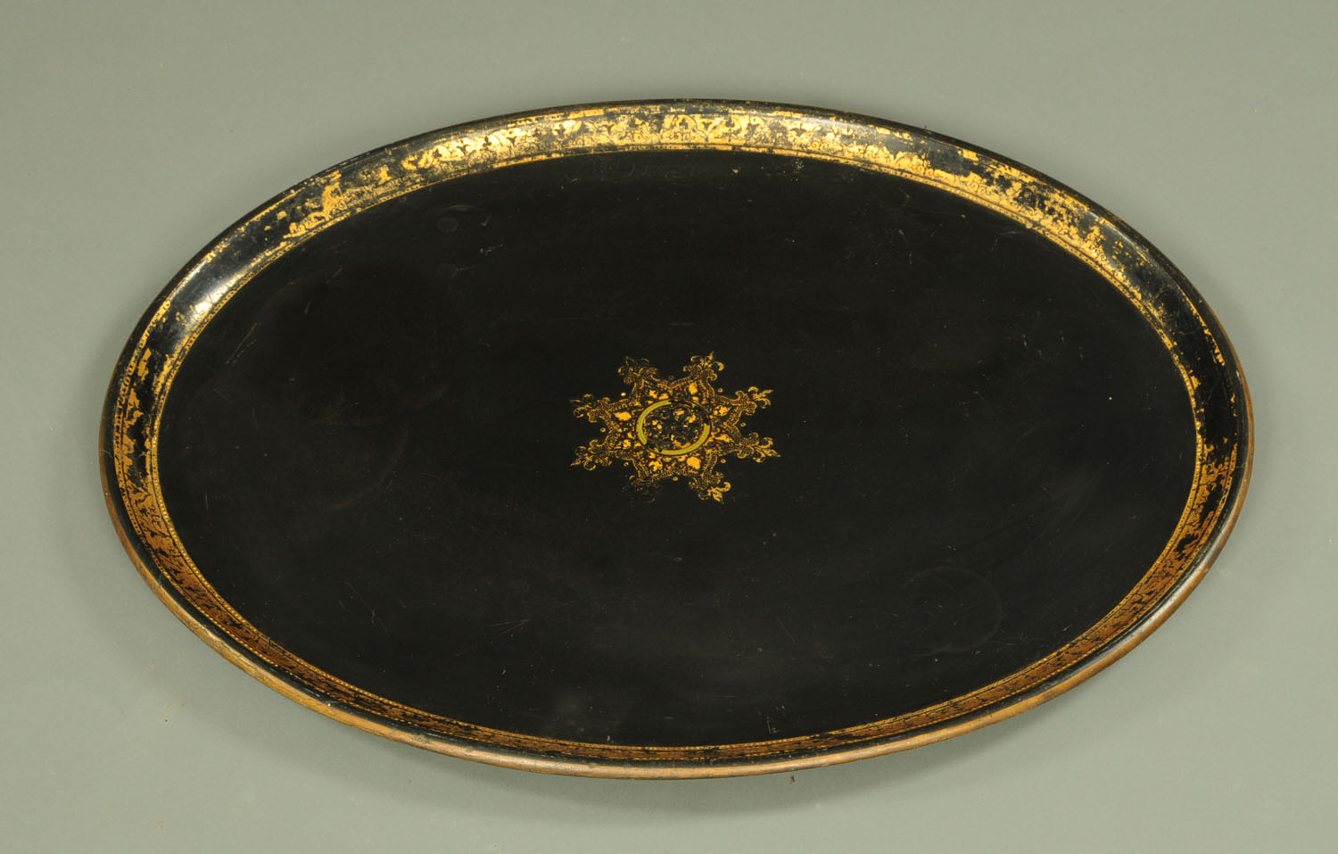 An early 19th century papier mache oval tray, with gilt medallion to centre and gilded borders,