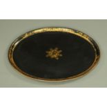 An early 19th century papier mache oval tray, with gilt medallion to centre and gilded borders,