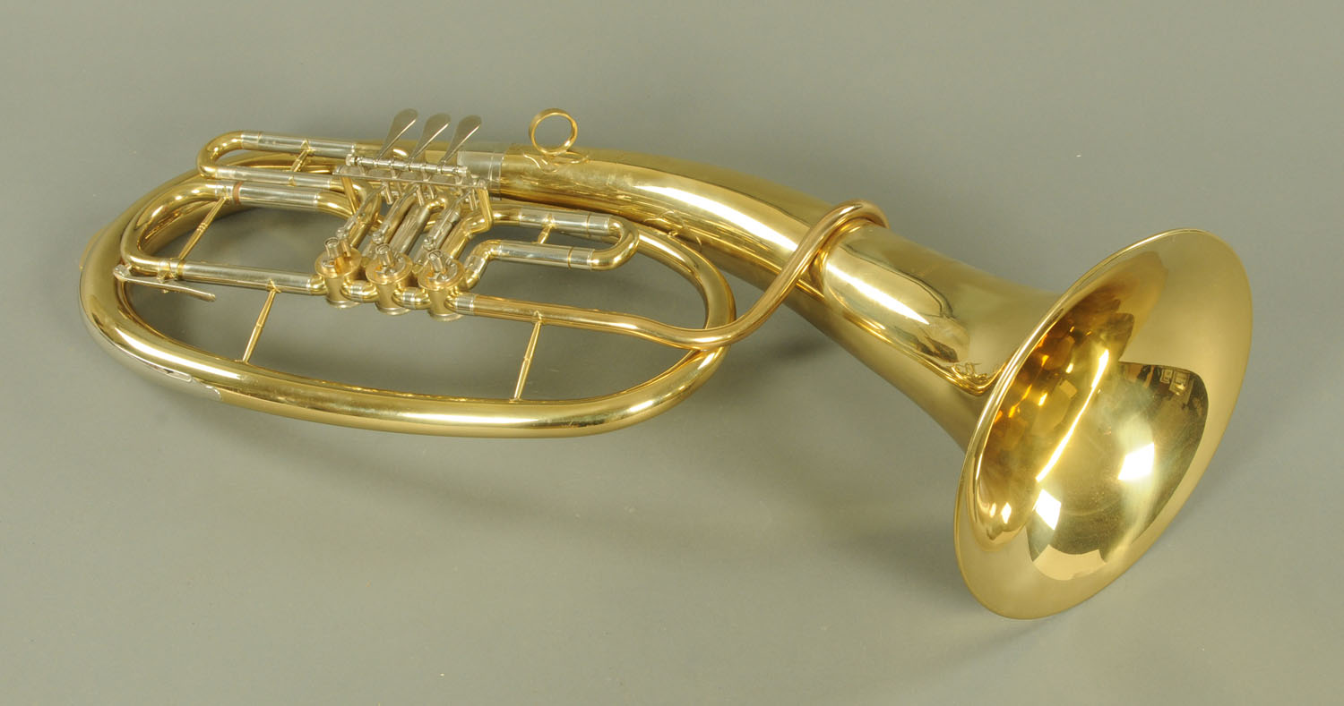 A brass baritone horn by Roy Benson, the horn with engraved name, +/- 74 cm long,