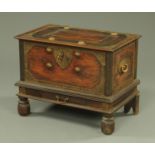 An African hardwood chest, early 19th century, with brass studs and engraved mounts,
