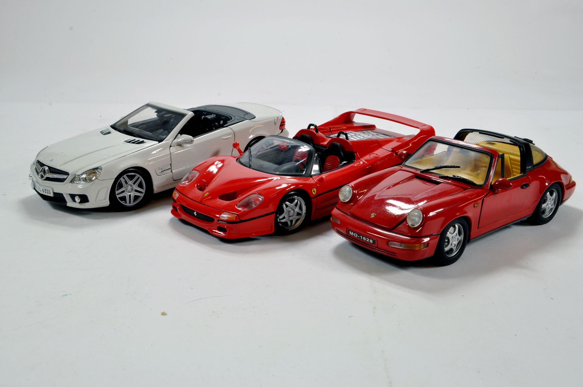 Trio of diecast cars. 1/18. Various makers Generally F to G.