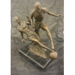 A modern bronze sculpture of two footballers