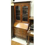 A 1920's walnut bureau bookcase with leaded glazed upper doors