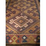 A Caucasian Kelim rug of blue, mustard and red colouring with brown end panels,