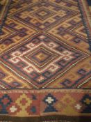 A Caucasian Kelim rug of blue, mustard and red colouring with brown end panels,