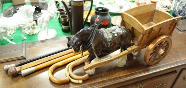 Six various walking sticks and a china shire horse and wooden cart ornament