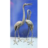 A pair of bronzed metal crane figures