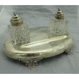 A Victorian silver desk standish of oval form, raised on four acanthus leaf style feet,
