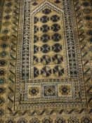 A Belouch rug, the central panel set with pillar design on a gold ground, within a stepped gold,