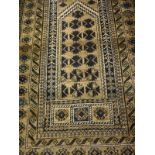 A Belouch rug, the central panel set with pillar design on a gold ground, within a stepped gold,