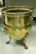 A brass coal bucket in the Arts and Crafts manner, raised on three splayed coppered legs,