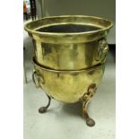 A brass coal bucket in the Arts and Crafts manner, raised on three splayed coppered legs,