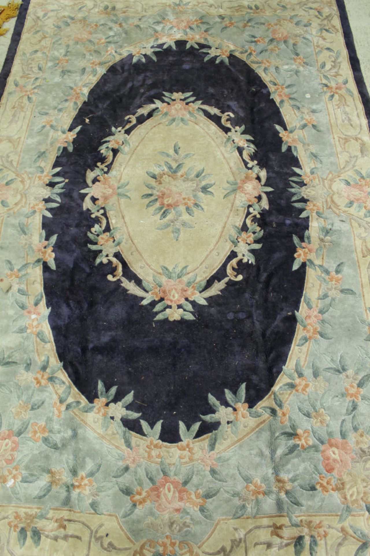 A Chinese silk rug, the central panel set with floral decorated medallion on a blue ground,
