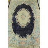 A Chinese silk rug, the central panel set with floral decorated medallion on a blue ground,