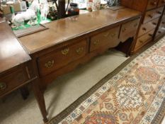 A 19th Century north country oak and cross-banded dresser base of three drawers on cabriole legs