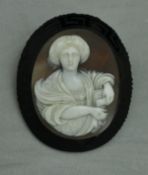 A Victorian carved shell cameo brooch depicting a lady with scroll in middle eastern dress within a