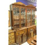 A pair of 19th Century mahogany bookcase cabinets with glazed and bared cabinet doors over drawers,