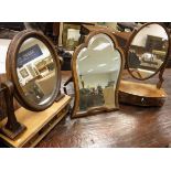 An early 19th Century mahogany toilet mirror, the oval plate on a three drawer base,