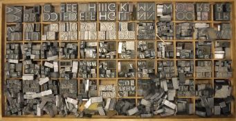 A wooden letter press tray containing various lead type set