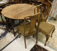 A oak drop leaf table together with four matching dining chairs with column shaped splat to green
