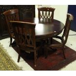 A modern reproduction circular dining table and four chairs with lozenge lattice work backs (seats