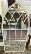 An arched lattice work mirror in the Gothic Revival style