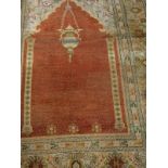 A Mirhab design carpet, the central panel set with hanging lantern on a terracotta ground,