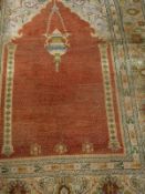 A Mirhab design carpet, the central panel set with hanging lantern on a terracotta ground,