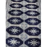 A Persian rug, the central panel set with repeating medallions on a dark blue ground,