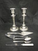 A pair of modern plated candlesticks in the classical taste together with a canteen containing