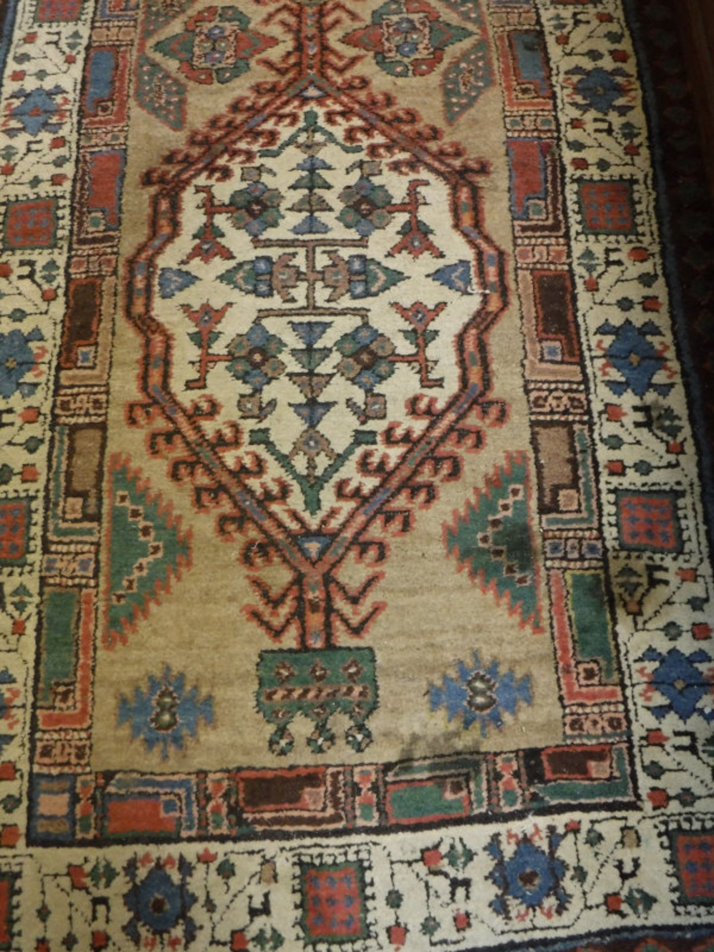 A fine Persian runner, the central panel set with repeating medallions on a cream ground,