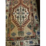 A fine Persian runner, the central panel set with repeating medallions on a cream ground,