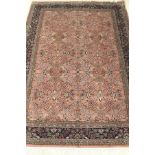 A Persian carpet, the central panel set with all over floral decoration on a pale pink ground,