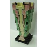 A Myott Art Deco stem vase of stepped form in green, black, pink,