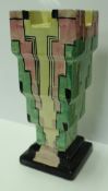 A Myott Art Deco stem vase of stepped form in green, black, pink,