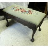 A carved mahogany duet piano / dressing stool with foliate decorated frieze on cabriole legs to