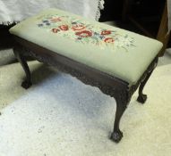 A carved mahogany duet piano / dressing stool with foliate decorated frieze on cabriole legs to