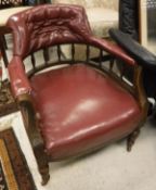 A Victorian walnut framed salon chair with red leather upholstery on turned and ringed supports to