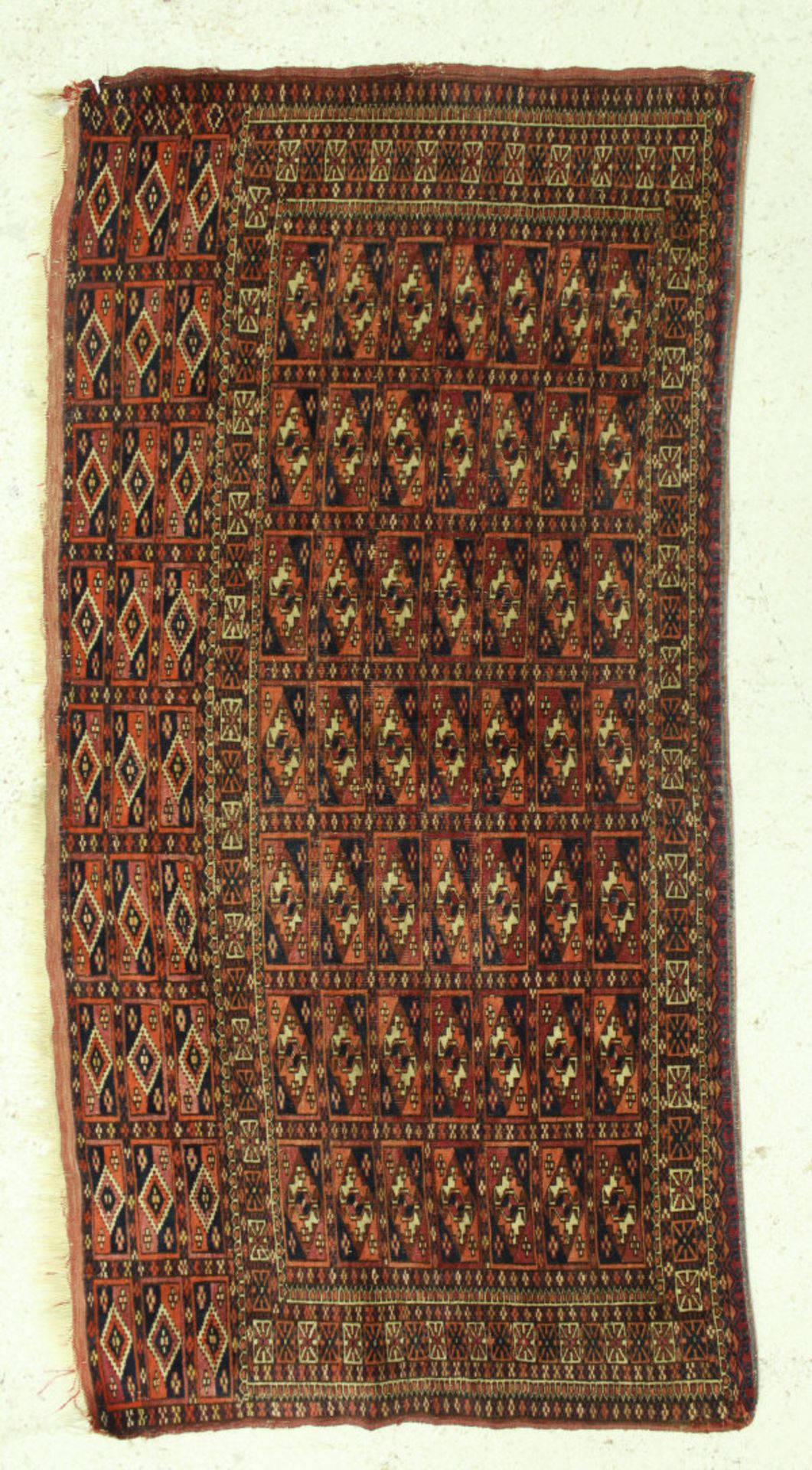 A Bokhara Torba rug, the main panel set with repeating tile design on a dark red ground, - Bild 2 aus 2