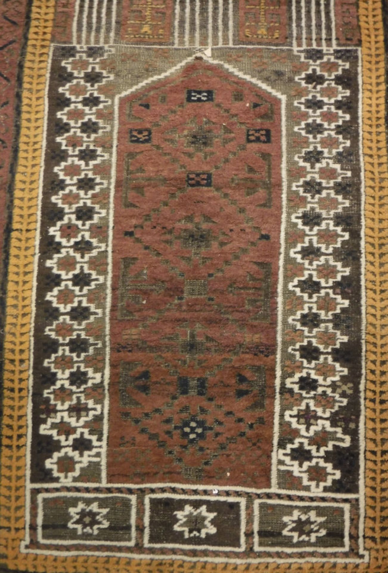 A Turkish prayer rug, the central panel set with pillar design on a brown ground,