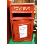 A red painted metal postbox inscribed "Postbox"