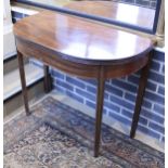 An early 19th Century mahogany fold-over tea table of demi-lune form,