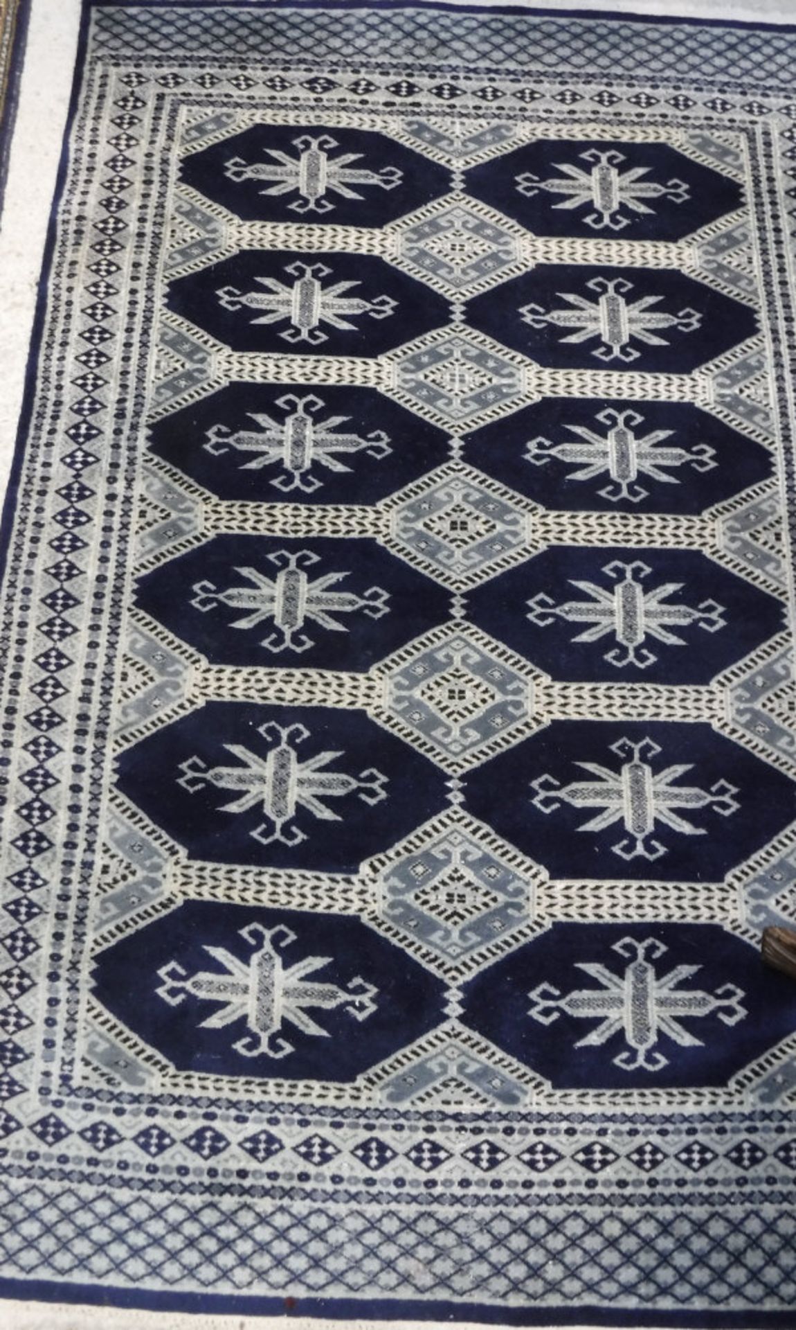 A Persian rug, the central panel set with repeating medallions on a dark blue ground, - Bild 2 aus 2