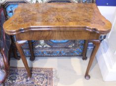 A walnut and feather-banded fold-over card table in the early 18th Century manner,